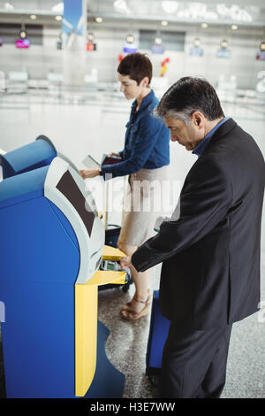 Les gens d'affaires à l'aide de self service check-in Banque D'Images