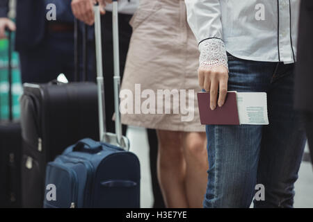 Passagers en possession d'un passeport et de l'attente dans la file d'embarquement Banque D'Images