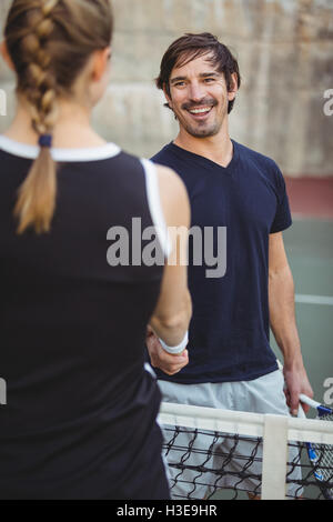 Les joueurs de tennis se serrer la main dans la cour Banque D'Images