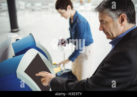 Businessman using self service check-in Banque D'Images