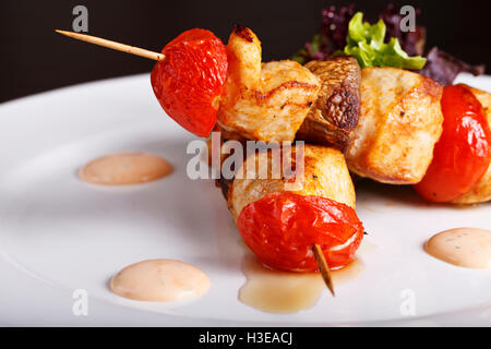 Une brochette de poulet en brochettes avec des tomates Banque D'Images