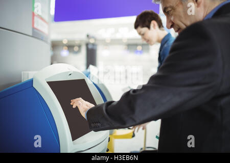 Businessman using self service check-in Banque D'Images