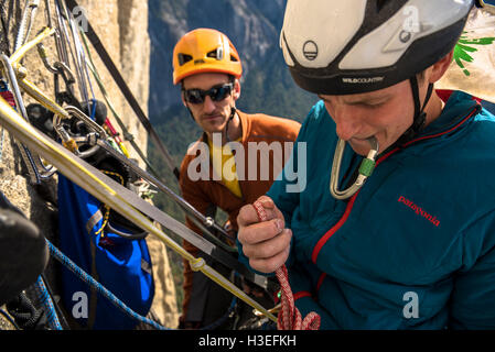 Deux hommes l'escalade libre un grand mur itinéraire sur El Capitan dans le Parc National de Yosemite Prk dans les montagnes de la Sierra Nevada, en Californie. Banque D'Images