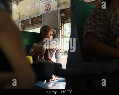 Un homme regarde par la fenêtre sur la ligne Circle train à Yangon, Myanmar (Birmanie) Banque D'Images