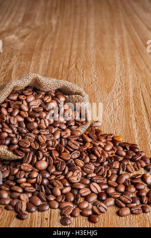 Sac de jute de grains de café sur la vieille table en bois Banque D'Images