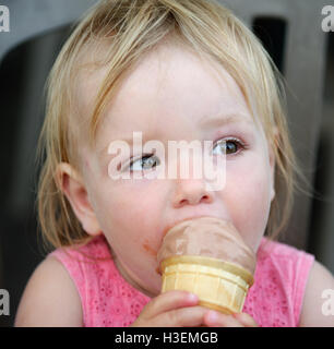 Une petite fille (2 ans) de manger une glace Banque D'Images