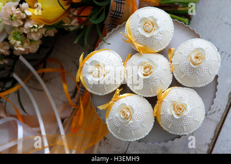 Beaux gâteaux et bouquet de mariée dans les tons orange Banque D'Images