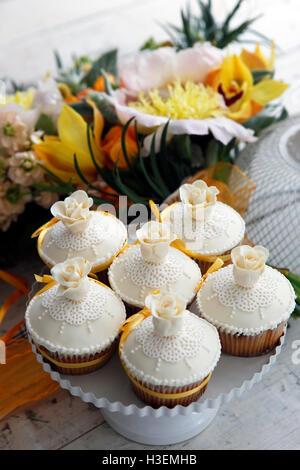 Beaux gâteaux et bouquet de mariée dans les tons orange Banque D'Images