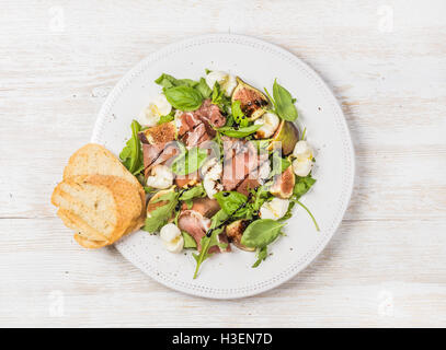 Le prosciutto, roquette, basilic, salade de figues et verre de vin rouge Banque D'Images