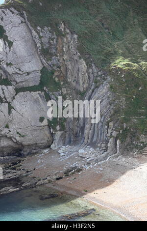 Une vue lointaine de l'étonnant strate rock formé il y a des millions d'années sur une extrémité de l'éperon rocheux à Durdle Door. Banque D'Images