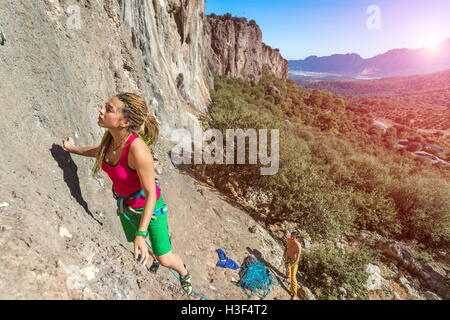 Jeunes talents Female Rock Climber ascending mur rocheux Banque D'Images