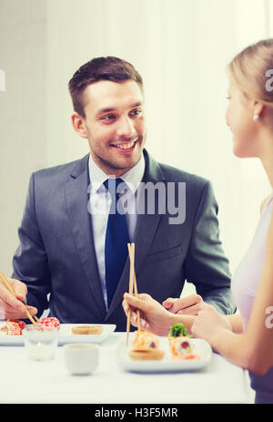 Smiling couple manger des sushis au restaurant Banque D'Images