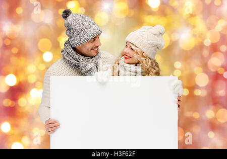 Couple dans des vêtements d'hiver avec tableau blanc vierge Banque D'Images