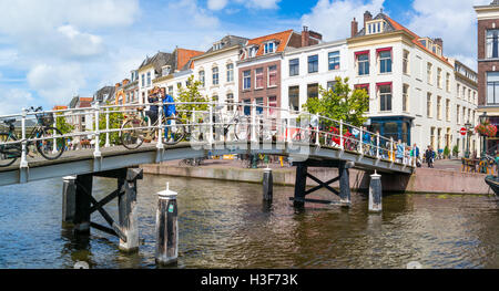 Les gens et les vélos sur le pont au-dessus du canal Rhin nouvelles et les pignons des maisons historiques dans le centre-ville de Leiden, Hollande méridionale, Pays-Bas Banque D'Images