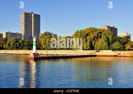 Ligne de pêcheurs un brise-lames à l'entrée du port de Montrose Chicago sur le lac Michigan à la fin de l'été, un matin. Banque D'Images