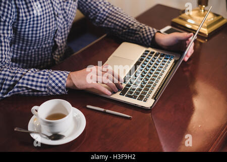 Au travail professionnel. Vue de dessus ofman working on laptop assis à son lieu de travail Banque D'Images