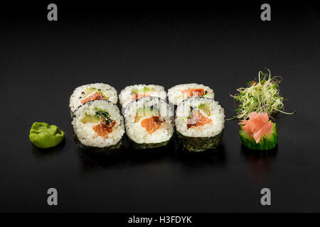 Petit ensemble de rouleaux de sushis frais décoré de salade d'algues et wasabi Banque D'Images