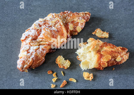 Deux croissants aux amandes sur fond sombre Banque D'Images