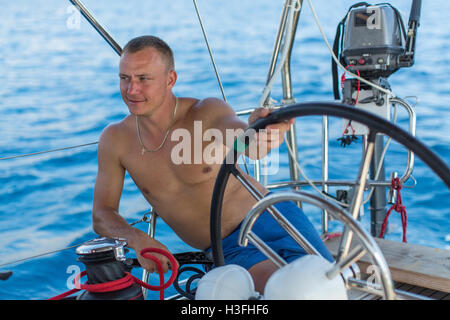 L'homme exécute son voile détendue skipper bateau yaht. Banque D'Images