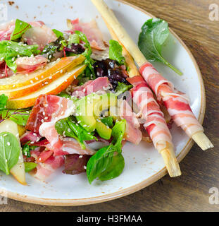 Salade fraîche à la pancetta et poire sur une table en bois. Vue de dessus Banque D'Images