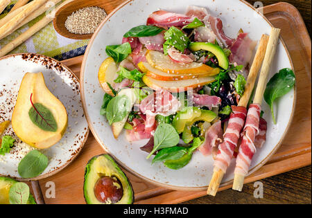 Salade fraîche à la pancetta et des bâtonnets sur une table en bois rustique. Vue d'en haut Banque D'Images