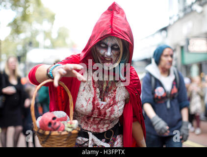 Une femme habillée en petit Chaperon Rouge morts pendant la journée à Zombie Embankment, London. Banque D'Images