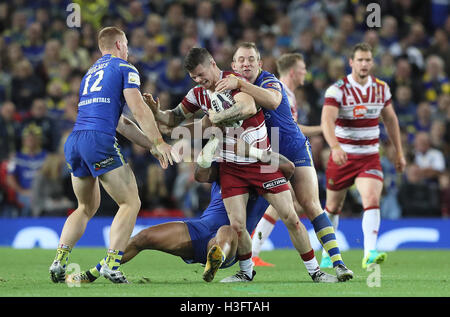 Wigan Warriors John Bateman est abordé par Warrington Wolves' Jack Hughes (à gauche) et George King (à droite) lors de la Grande Finale de la Super League à Old Trafford, Manchester. Banque D'Images