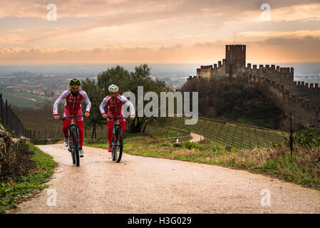 Soave, Italie - 27 mars 2016 : Les cyclistes train après une tempête sur les collines entourant le château de Soave. Banque D'Images