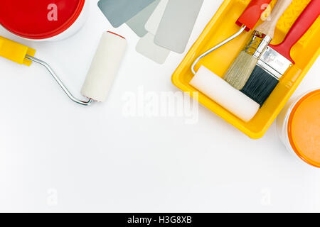 Rouleaux de peinture dans le bac, les brosses et les pots de peinture avec l'échantillon de couleur Banque D'Images