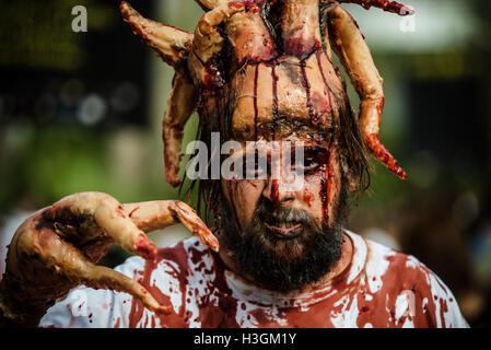 Sitges, Espagne. Octobre 9th, 2016. Un homme dans son costume Zombie se réchauffe sur la promenade d'effrayer par des passants avant l'Sitges Zombie Walk 2016 Credit : matthi/Alamy Live News Banque D'Images