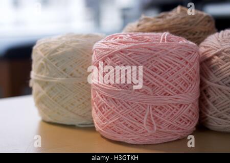 Boules de coton laine fils de soie sur table en bois brun et Rose Blanche Banque D'Images