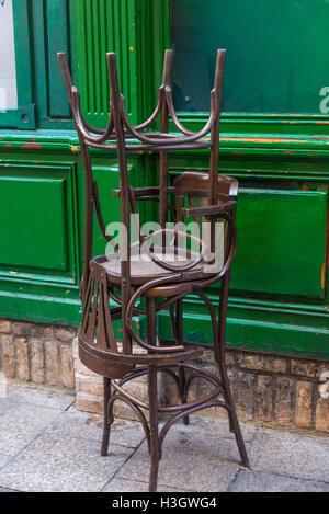 Chaises en bois empilé en face d'une brasserie fermée Banque D'Images