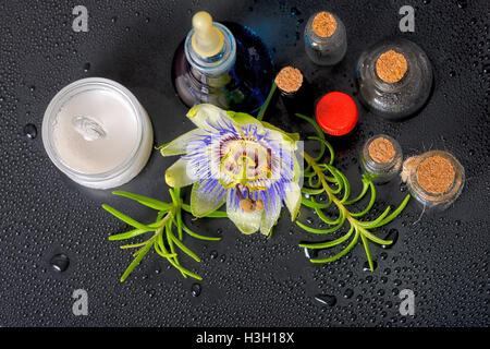 Haut en bas de la composition spa blue passiflora, fleur de sel et le parfum de mortier cosmétique des bouteilles vides sur les pierres zen avec la rosée, clo Banque D'Images