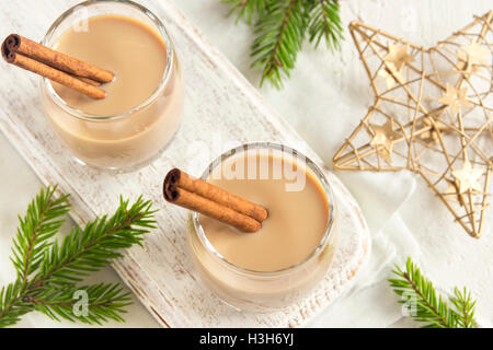 Noël : lait de poule à la cannelle dans des verres avec des branches de sapin et des ornements traditionnels faits maison - boisson festive pour Noël Banque D'Images