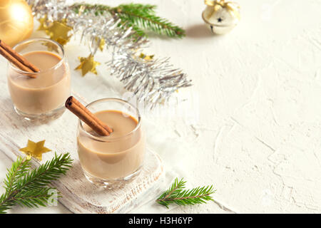 Noël : lait de poule à la cannelle dans des verres avec des branches de sapin et des ornements traditionnels faits maison - boisson festive pour Noël ti Banque D'Images