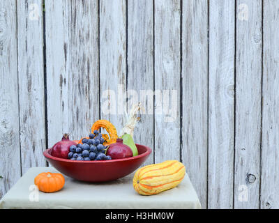 Gros plan sur les fruits et légumes récoltés dans la fin de l'été, dans le panier rouge, sur tan, nappe décorée de blé d'inde Banque D'Images