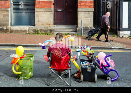 Man making animaux avec des ballons de derrière Banque D'Images