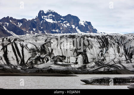 Couvert de cendres et de l'eau de fonte du glacier Skaftafell lagune glaciaire du parc national de Vatnajökull en Islande Banque D'Images