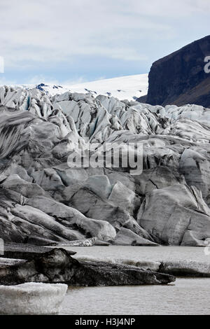 Couvert de cendres et de l'eau de fonte du glacier Skaftafell lagune glaciaire du parc national de Vatnajökull en Islande Banque D'Images