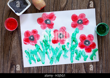 Dessin sur papier coquelicots réalisés dans la technique de pommes de terre d'empreintes digitales et les doigts. Peinture, Colle, papier et les pommes de terre sur un sol en bois Banque D'Images