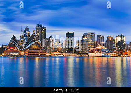 Paysage urbain de la ville de Sydney CBD sur Harbour au lever du soleil, reflétant les lumières vives des gratte-ciel et date majeure dans encore flou Banque D'Images