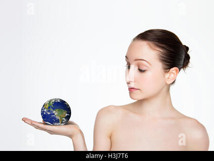 Beautiful woman holding globe terrestre sur son bras sur fond blanc Banque D'Images