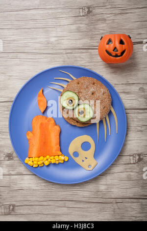 Halloween spider, bougie et crâne fait de pain et de légumes à bord Banque D'Images