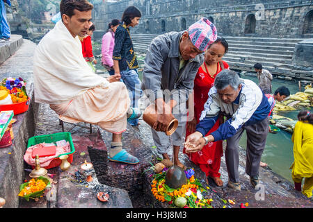 Les Népalais puja par un shivalingam au temple de Pashupatinath, Katmandou, Népal Banque D'Images