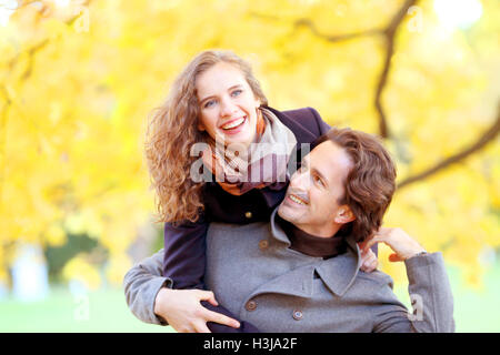 Smiling couple having fun in autumn park Banque D'Images