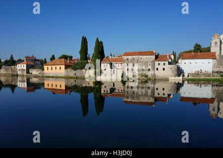 Ville close pierre méditerranéen reflète dans une belle rivière propre avec ciel bleu, arbres et vieux bâtiments de pierre. Banque D'Images