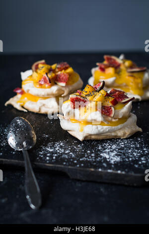 Pavlova dessert avec lait caillé de citron, figues fraîches et les graines de pavot. Vertical, selective focus Banque D'Images