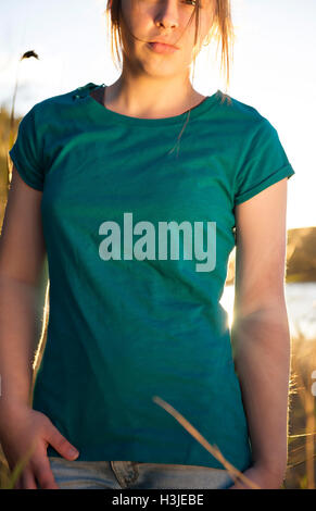 Jeune fille au coucher du soleil portant un T-shirt blanc Banque D'Images