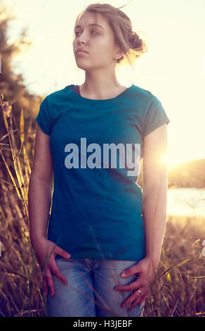 Jeune fille au coucher du soleil portant un T-shirt blanc Banque D'Images