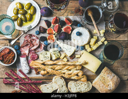 Vin et snack-set avec différents vins au verre, viandes diverses, ciabatta, tomates séchées, miel, olives vertes, figues, noix un Banque D'Images